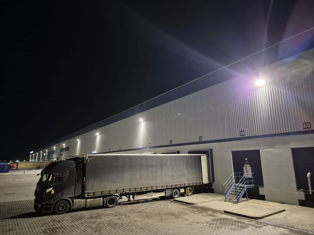 Ciężarówka przy rampie magazynowej oświetlona nowoczesnym oświetleniem zewnętrznym