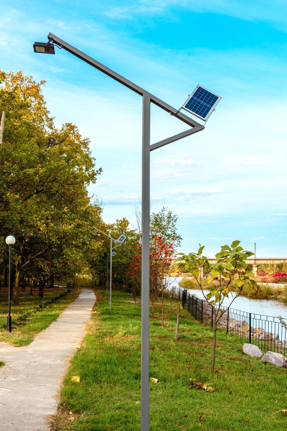 Lampy parkowe LED z panelami solarnymi nad ścieżką przy rzece
