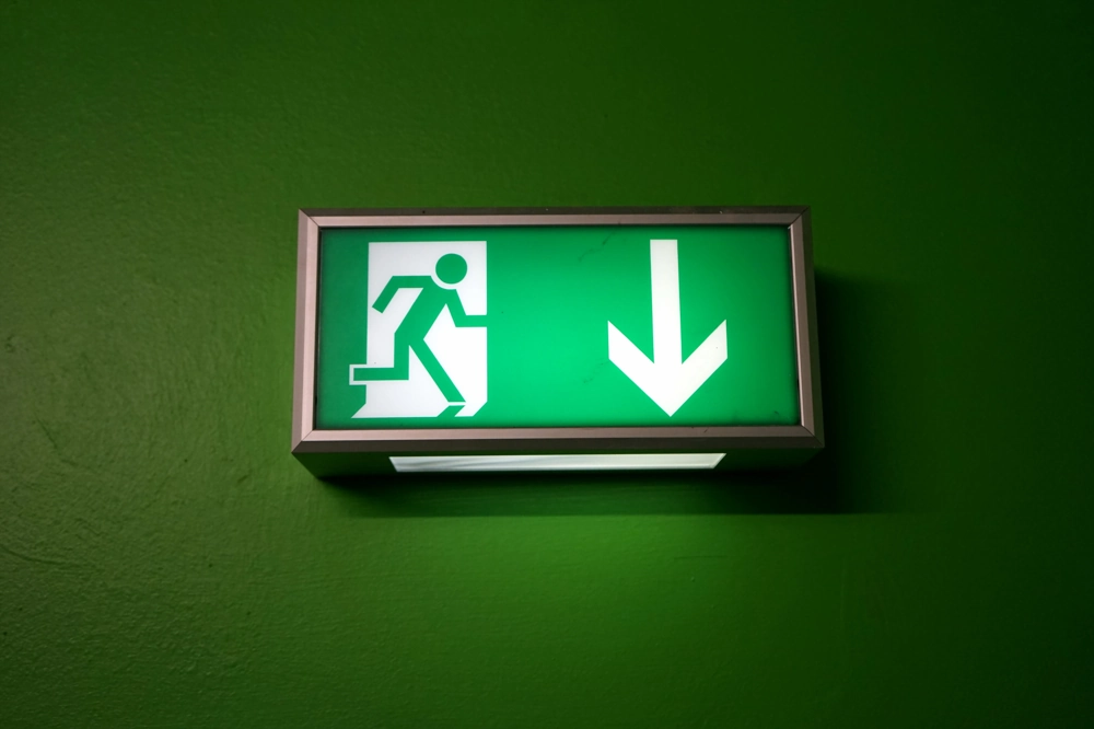 Podświetlany zielony znak oświetlenia ewakuacyjnego ze strzałką w dół