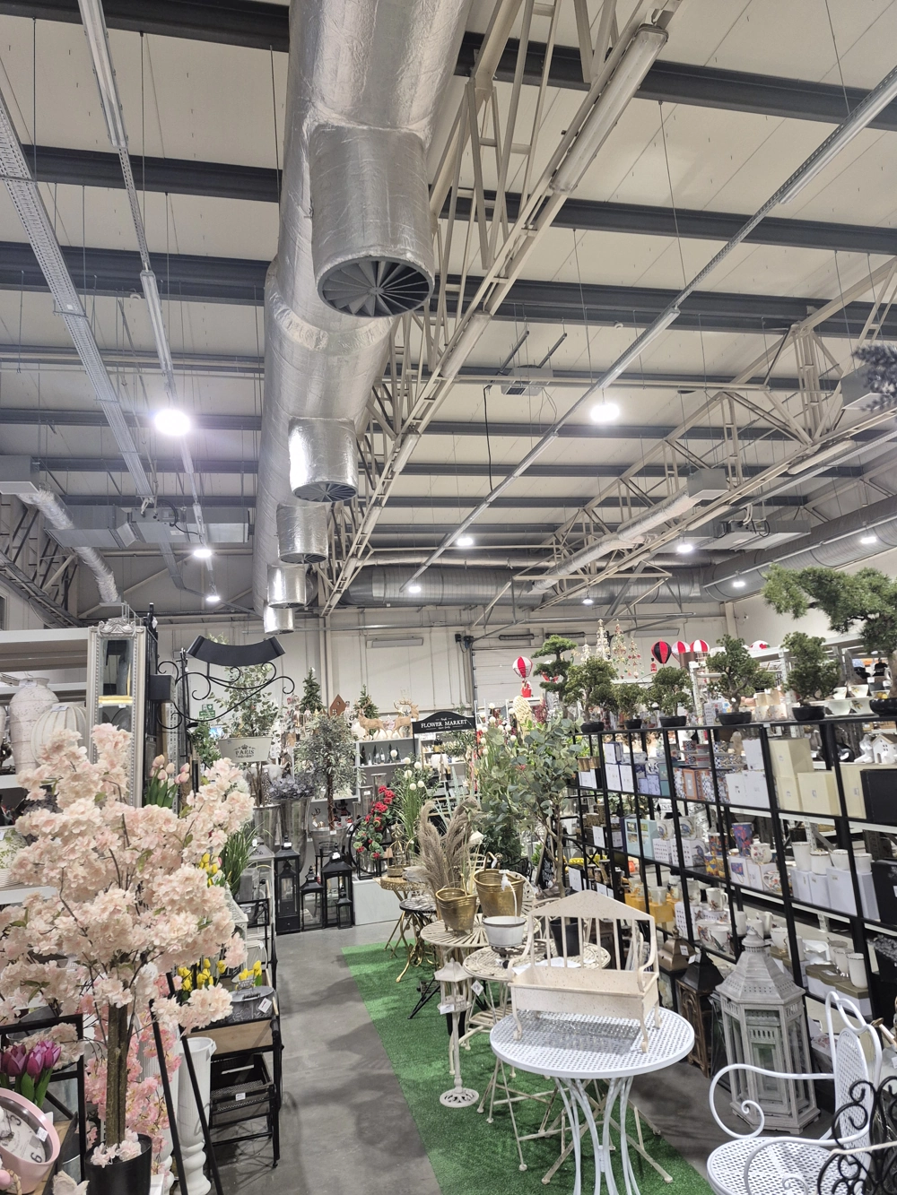 Stoisko w hali z meblami, roślinami i dekoracjami, oświetlone oświetleniem wewnętrznym LED