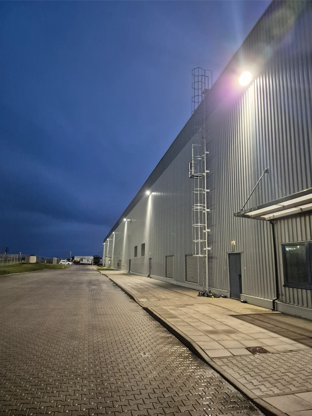 Elewacja hali przemysłowej oświetlona zewnętrznymi naświetlaczami LED