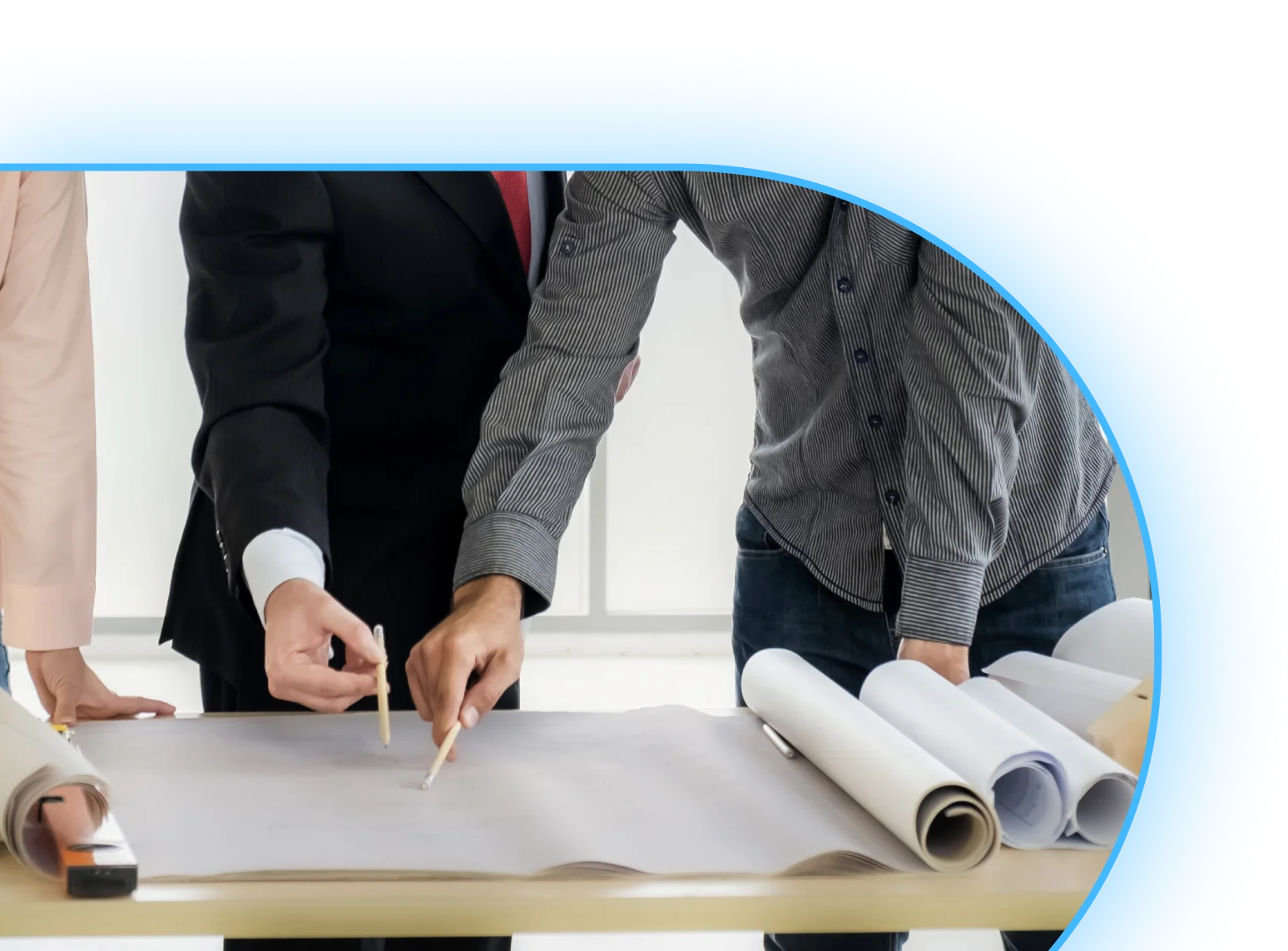 Dwie osoby przy stole pracujące nad rozłożonymi planami oświetleniowymi w ramach projektu Dialux