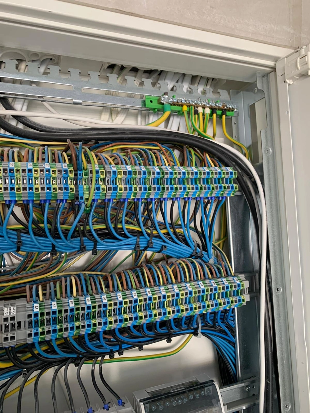 Widok wnętrza rozdzielnicy z szeregami oznaczonych złączy i uporządkowanym okablowaniem, Rozdzielnice elektryczne