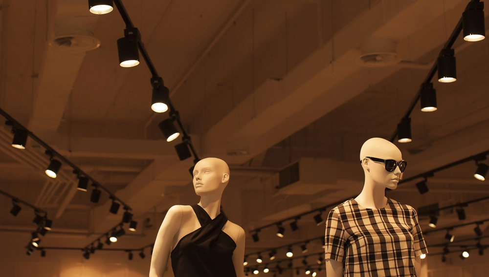 Oświetlenie sklepu z manekinami odzieżowymi pod designerskimi szynowymi lampami LED