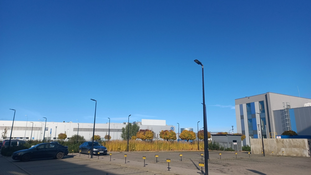 Słupy z lampami LED oświetlające zewnętrzny plac przy hali przemysłowej